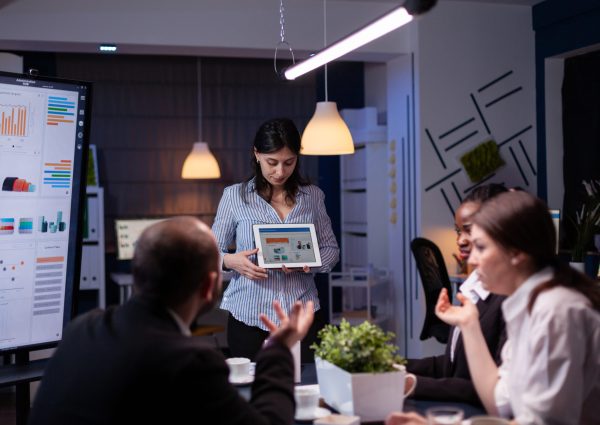 overworked workaholic entrepreneur woman shwoing marketing graphs using tablet